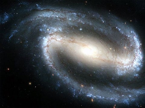 Spirální galaxie s příčkou jsou podobné normálním spirálním galaxiím. Jejich spirální ramena se ale nenapojují na jádro přímo, ale přes příčku, která se otáčí stejnoměrně spolu s jádrem. NGC 1300. Obraz z Hubbleova vesmírného dalekohledu. 